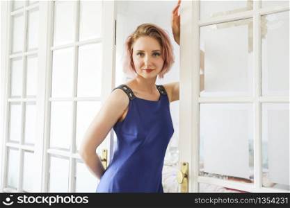 young beautiful lady posing in the living room next to a window