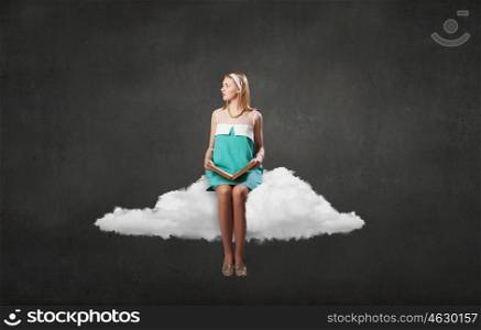 Young beautiful lady sitting on cloud with book in hands. Girl with book