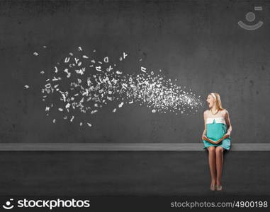 Young beautiful lady sitting on roof with book in hands. Girl with book