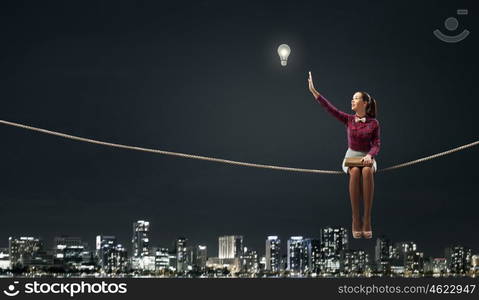 Young beautiful lady sitting on rope and reading book