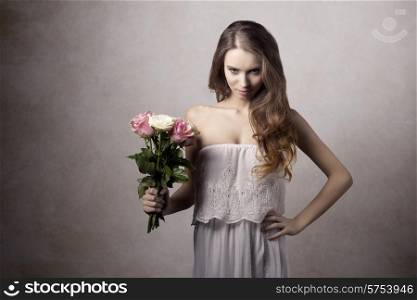 Young, beautiful, little bit angry blonde girl in white dress and bouquet of roses with nude makeup.