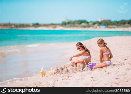 Young beautiful mother and her adorable little daughter have fun at tropical beach. Beautiful mother and daughter on the beach enjoying summer vacation