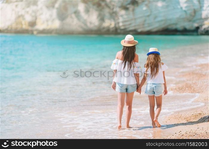 Young beautiful mother and her adorable little daughter on tropical beach. Beautiful mother and daughter on Caribbean beach
