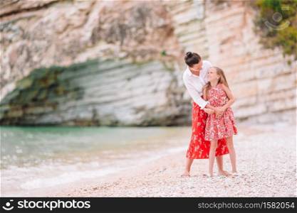 Young beautiful mother and her adorable little daughter on tropical beach. Beautiful mother and daughter on Caribbean beach