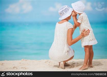 Young beautiful mother and her little daughter on the beach. Beautiful mother and daughter at the beach enjoying summer vacation