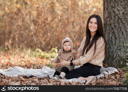 Young beautiful mother playing with her daughter in autumn park on sunny day. mother&rsquo;s day.. Young beautiful mother playing with her daughter in autumn park on sunny day. mother&rsquo;s day