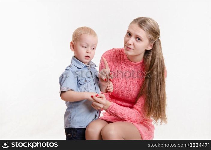 Young beautiful mother scolds her rebellious and moody three year old boy