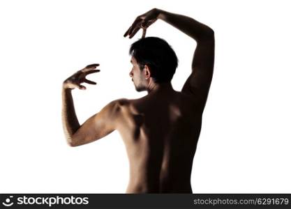 Young beautiful naked man dancing on white background