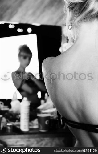 Young beautiful naked woman model in the mirror