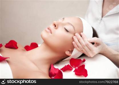 Young beautiful relaxing woman having a facial massage