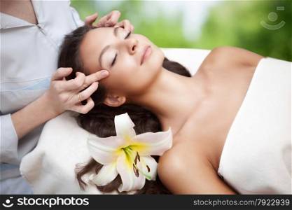 Young beautiful relaxing woman having a facial massage
