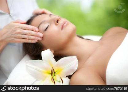 Young beautiful relaxing woman having a facial massage.