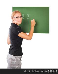 Young beautiful smart teacher writing numbers on green chalkboard isolated on white background, to teach in an elementary school