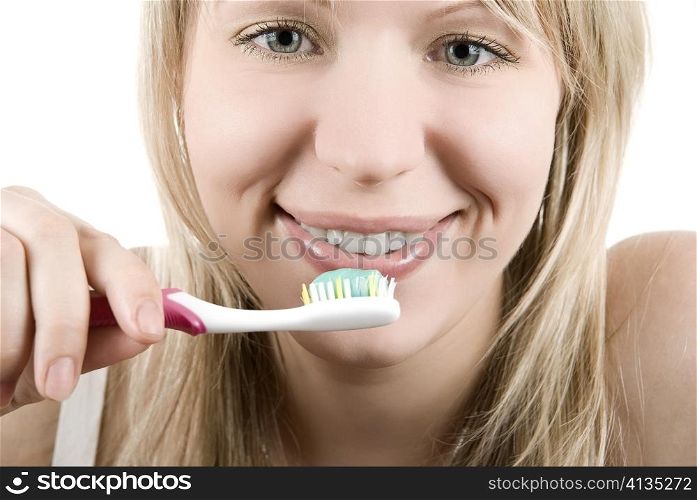 Young beautiful smiling woman with white teeth holding a tooth brush