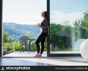 young beautiful successful woman eating breakfast in the doorway of her luxury home villa