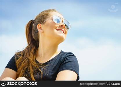 Young beautiful teenage woman spending her leisure time outside relaxing during summertime warm weather enjoying herself.. Younwg woman relaxing outdoor