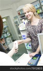 Young Beautiful Woman Buying with Credit Card in the Pharmacy