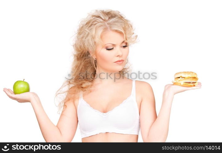 young beautiful woman choosing between burger and apple