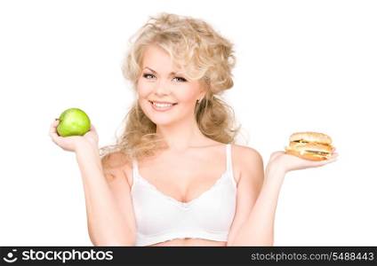 young beautiful woman choosing between burger and apple.