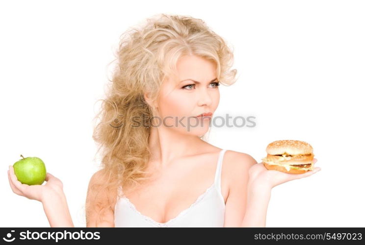 young beautiful woman choosing between burger and apple