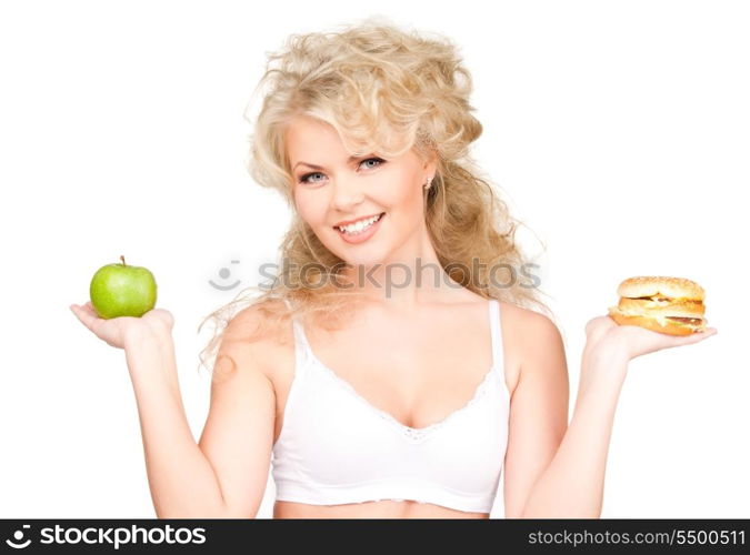 young beautiful woman choosing between burger and apple