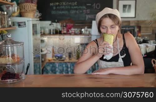 Young beautiful woman cook enjoying the vegetable soup in baked cone and giving thumb up