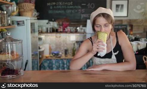 Young beautiful woman cook enjoying the vegetable soup in baked cone and giving thumb up