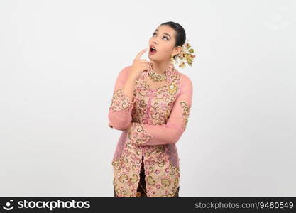 Young beautiful woman dress up in local culture in southern region standing and point finger near her cheek during great idea or thought on white background