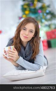 young beautiful woman drinking a tea indoors at christmas time