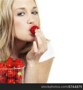 Young beautiful woman eating fresh strawberry