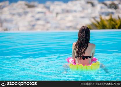 Young beautiful woman enjoying summer vacation in outdoor luxury swimming pool. Young beautiful woman enjoying summer vacation in outdoor swimming pool