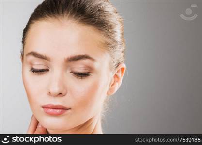 Young beautiful woman face portrait with healthy skin, eyes closed. Young woman face portrait