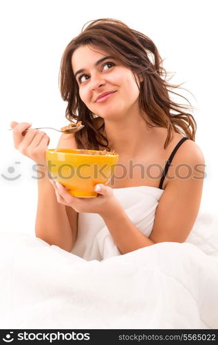 Young beautiful woman having breakfast in bed