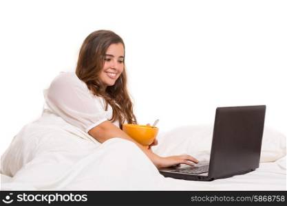 Young beautiful woman having breakfast in bed