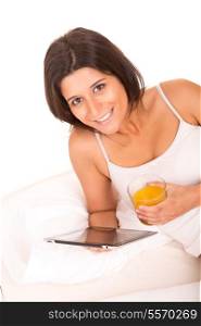 Young beautiful woman having breakfast in bed while working or relaxing with her computer