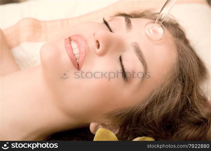 Young beautiful woman having facial treatment in spa salon