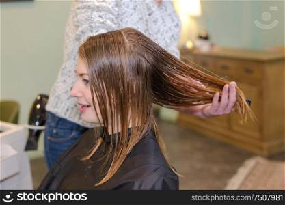 young beautiful woman having her hair cut at the hairdressers