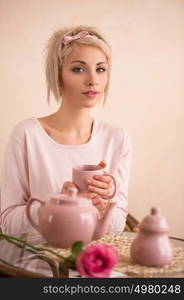 Young beautiful woman having tea-party in pink feminine style. She is very satisfacted. Valentine's day or international women's day celebration.