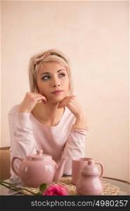 Young beautiful woman having tea-party in pink feminine style. She is very satisfacted. Valentine's day or international women's day celebration.