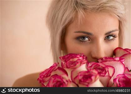 Young beautiful woman holding bouquet of pink roses. She is very satisfacted. Valentine's day or international women's day celebration.
