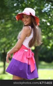 Young beautiful woman in a red hat in summer park