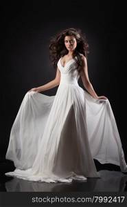 Young beautiful woman in a wedding dress on a black background