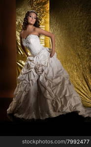 Young beautiful woman in a wedding dress on a studio background