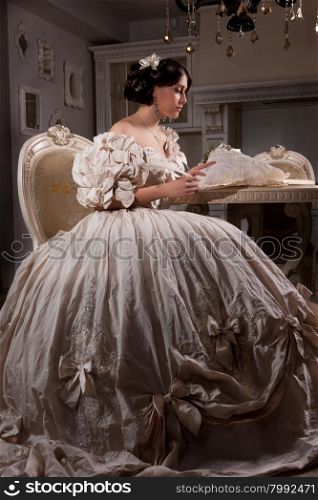 Young beautiful woman in a wedding dress sitting at the round table