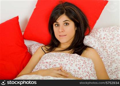 young beautiful woman in bed, studio picture