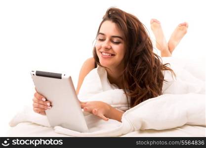Young beautiful woman in bed, working or relaxing with her computer