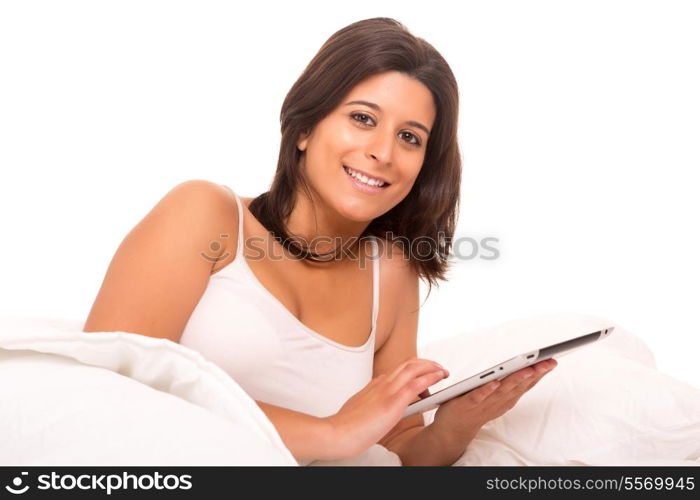 Young beautiful woman in bed, working or relaxing with her computer