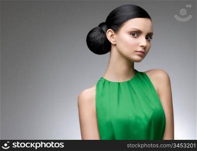 young beautiful woman in green dress, studio shot