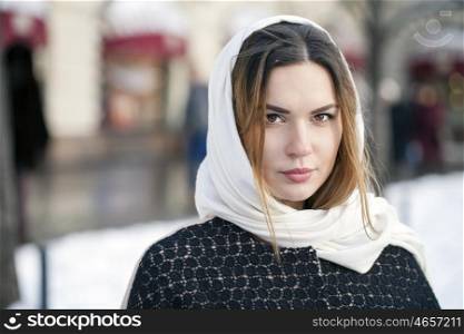 Young beautiful woman in stylish dark gray wool coat on a background of a winter street