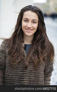 Young beautiful woman in stylish mink coat on a background of a winter street